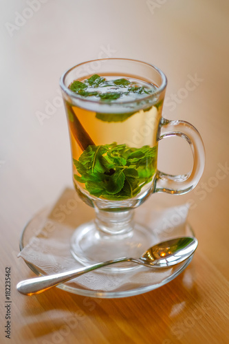 Mint tea with cinnamon in a transparent cup on the table