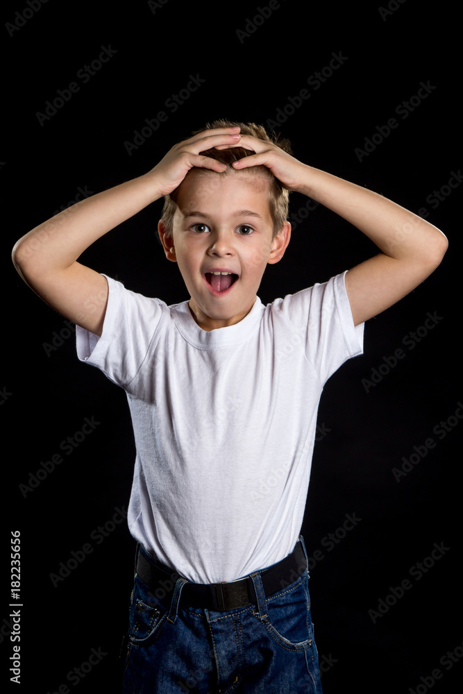 An open eyed boy portrait with hands on the top of the head. Sincere emotions of people An open eyed boy portrait with hands on the top of the head. Sincere emotions of people