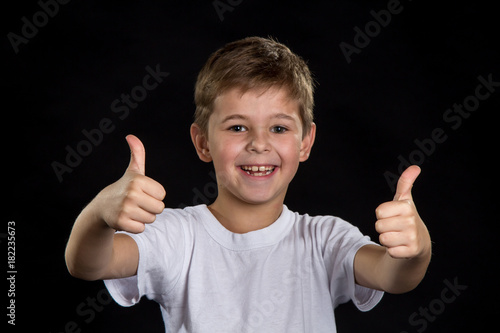 Extremely happy, cheerful and smiling boy with thumbs up