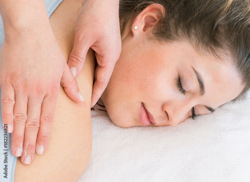 entspannende Handmassage im Rückenbereich bei junger Frau im Kosmetikstudio entspannende Handmassage im Rückenbereich bei junger Frau im Kosmetikstudio