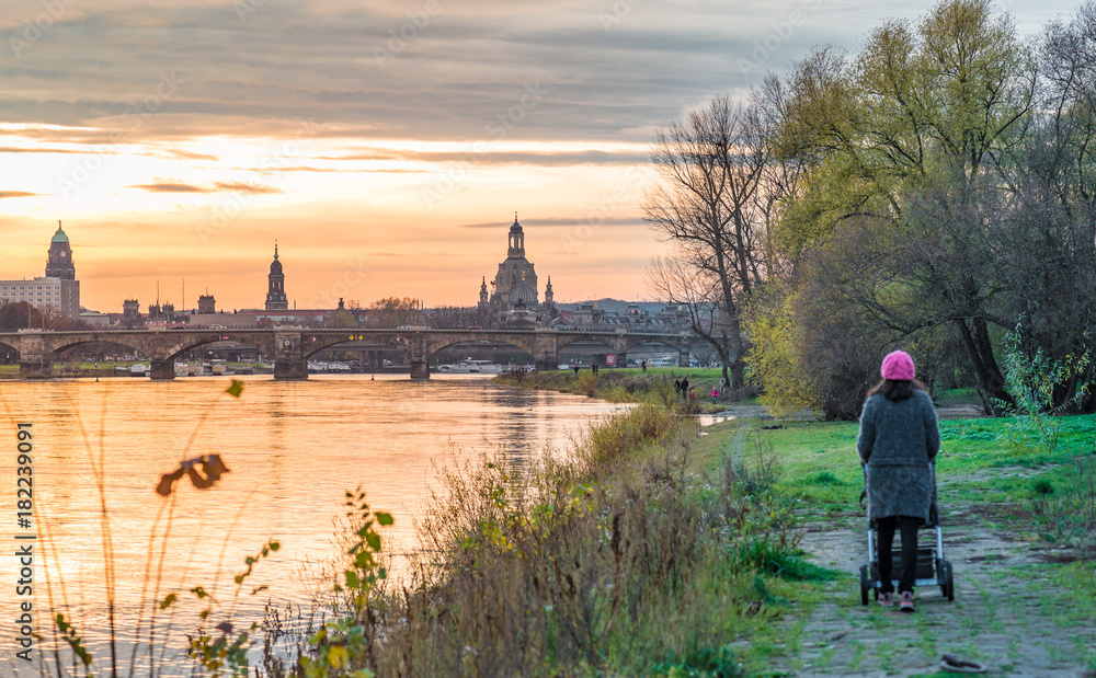 Obraz premium Spaziergang mit Kinderwagen bei Sonnenuntergang in Dresden