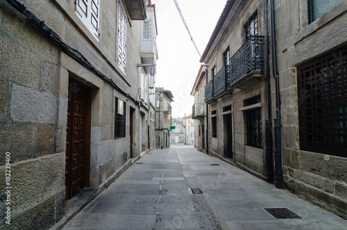 Empty street in town's historic quarter Pontevedra (Spain). Masonry walls steel gratings in the windos and wood door. Horizontal.