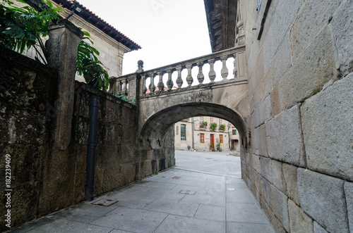 Fototapeta Naklejka Na Ścianę i Meble -  Romanic small arch bridge crossing over the street in Pontevedra Spain