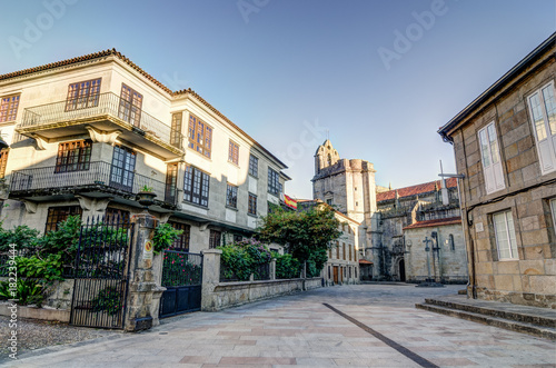 A square in Pontevedra (Spain) with a church as background and some buildings with plants and a spanish flag