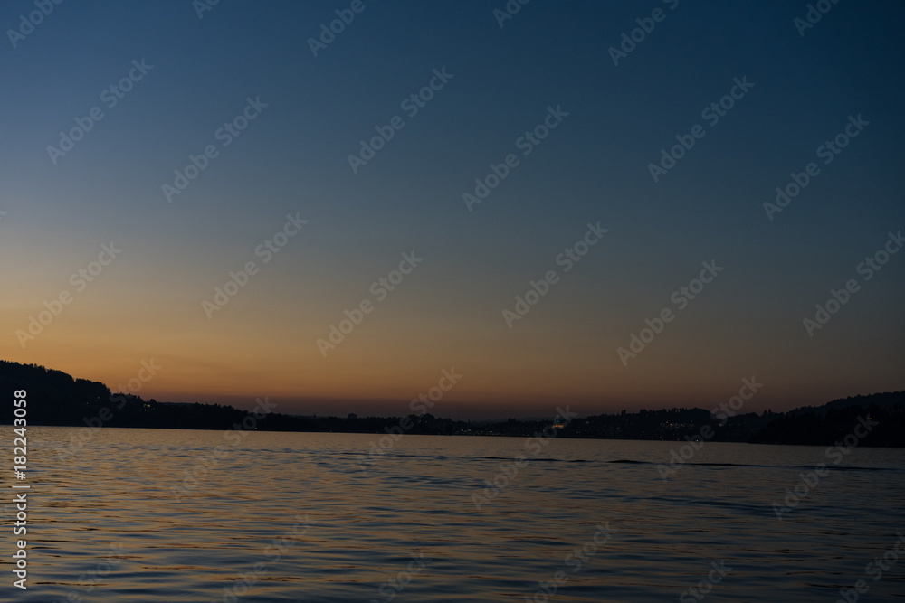 sunset on lake lucerne with mountains viewed from boat clear sky