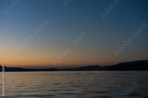 sunset on lake lucerne with mountains viewed from boat clear sky © DSGNSR