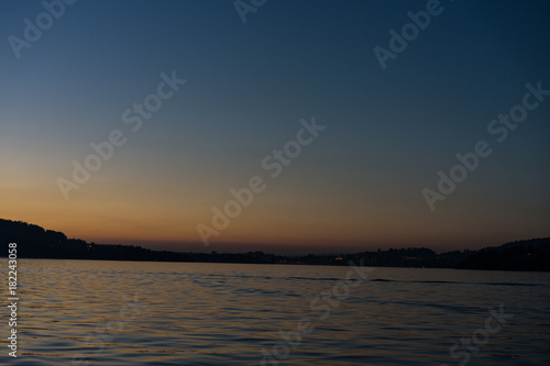 sunset on lake lucerne with mountains viewed from boat clear sky © DSGNSR