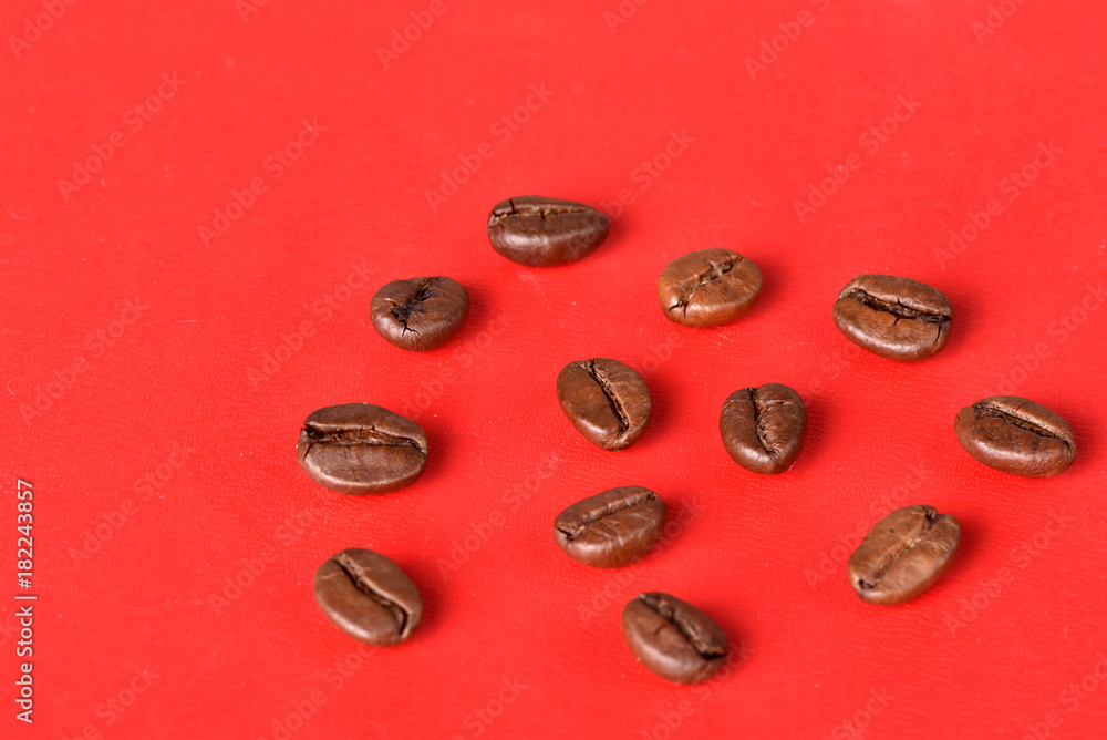 Texture of grains of caffeine.Place for text.Roasted coffee beans.Advertising for coffee.Coffee beans on a red background. Texture of grains of caffeine.Place for text.Roasted coffee beans.Advertising for coffee.Coffee beans on a red background.
