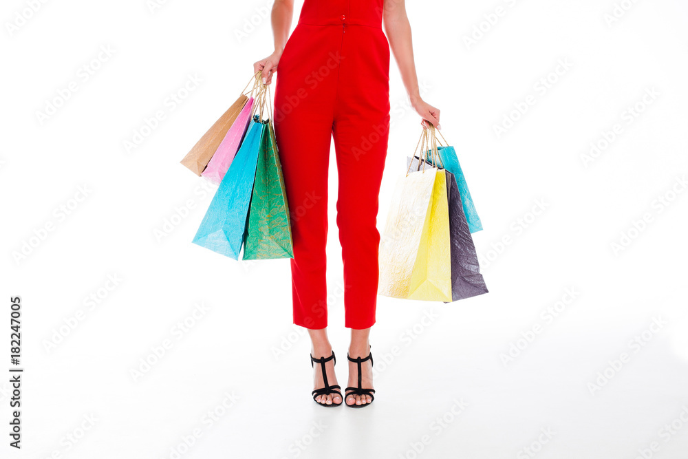 Amazing shopping! Part of young woman holding shopping bags while standing against white background