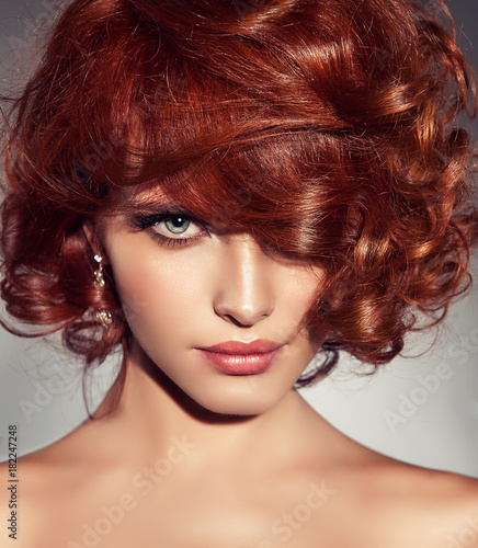 Beautiful model girl with short red curly hair .Red head hairstyle . Care and beauty hair products 