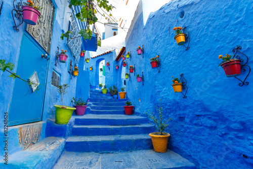 Famous Blue City Chefchauen at Morocco. Colorful flowerpots on the blue wall of old building. Travel destination concept. © Visual Intermezzo