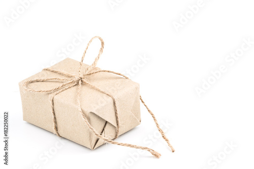 Vintage brown craft paper gift box tied with brown rope bow ribbon isolated on white background for Christmas, New Year and Valentine Day present.