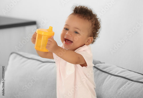 Cute baby with bottle of wa...