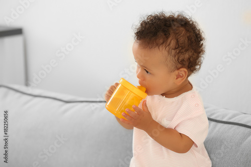 Cute baby with bottle of wa...
