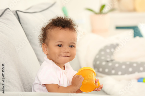 Cute baby with bottle of wa...