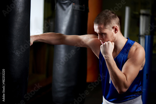 Boxing. Portrait of a boxer on the background of the gym © amixstudio