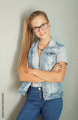 Cute teenager girl on grey ...
