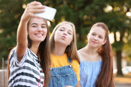 Cute teenagers taking selfie outdoors