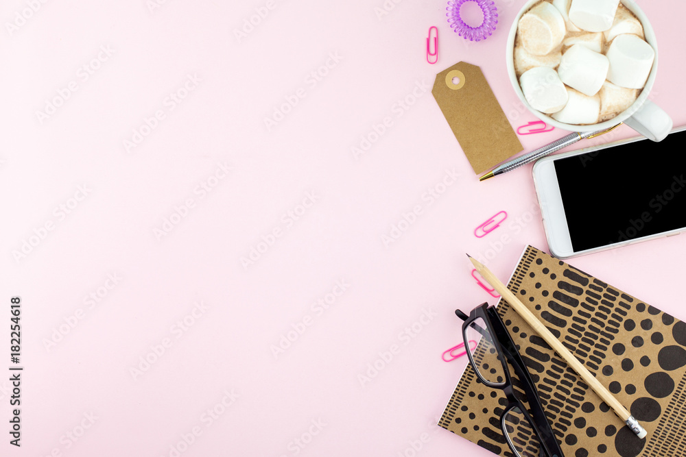 Creative flat lay photo of workspace desk with smartphone, eyeglasses, pen, pencil and notebook with copy space background, minimal style on pink background Creative flat lay photo of workspace desk with smartphone, eyeglasses, pen, pencil and notebook with copy space background, minimal style on pink background