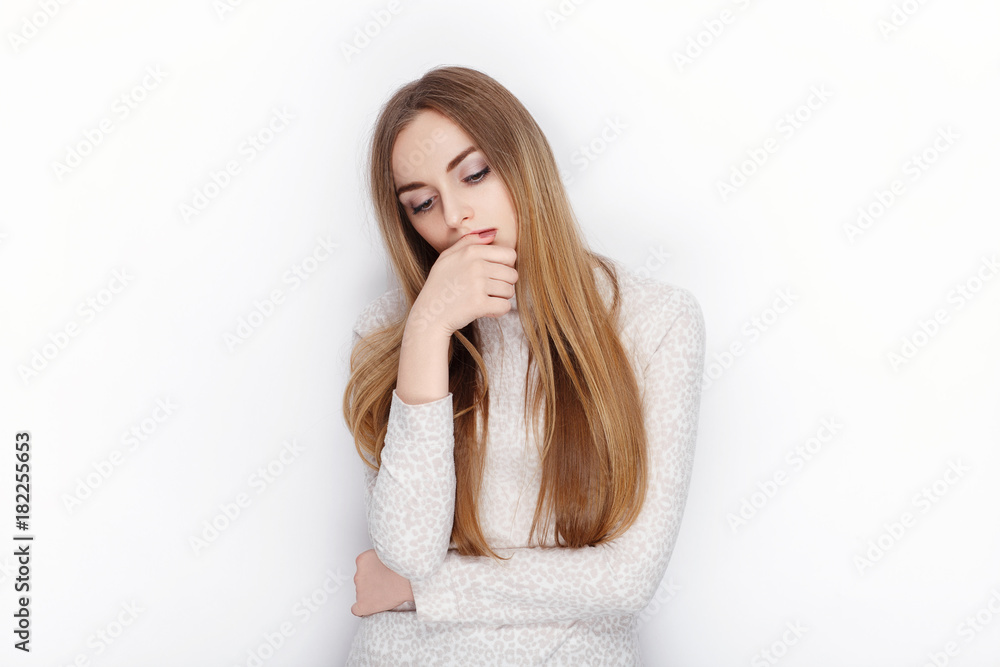 Beautiful emotional blonde female model looking pensive wear pajamas. Communication patterns concept.