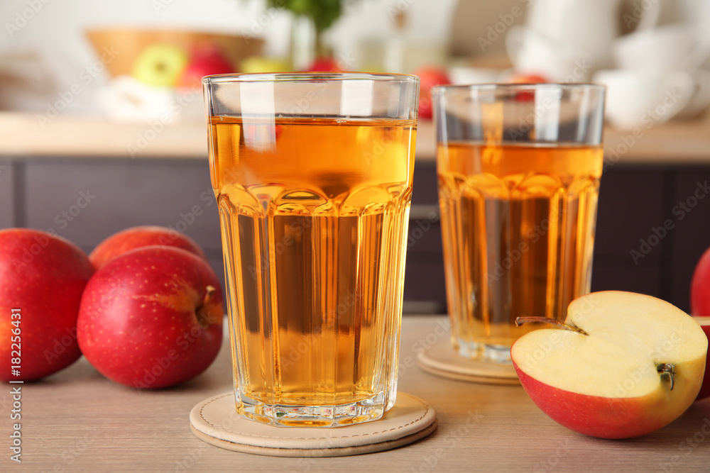 Glasses with apple juice on kitchen table Glasses with apple juice on kitchen table