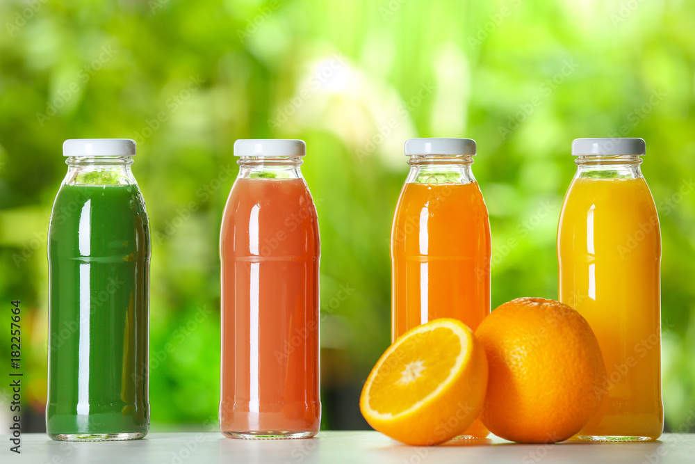 Bottles with fresh juices on table outdoors Bottles with fresh juices on table outdoors