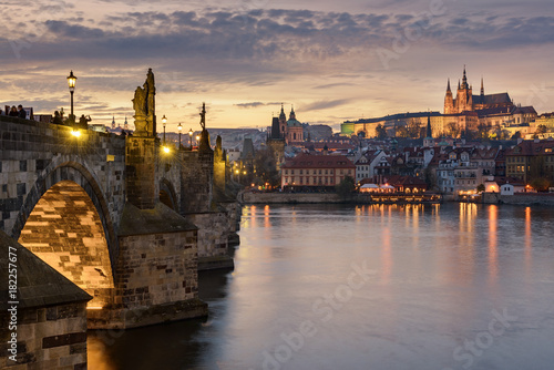 Charles Bridge and Prague Castle in Prague with sunset sky in background