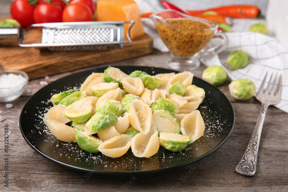 Plate of pasta with Brussels sprouts and cheese on table