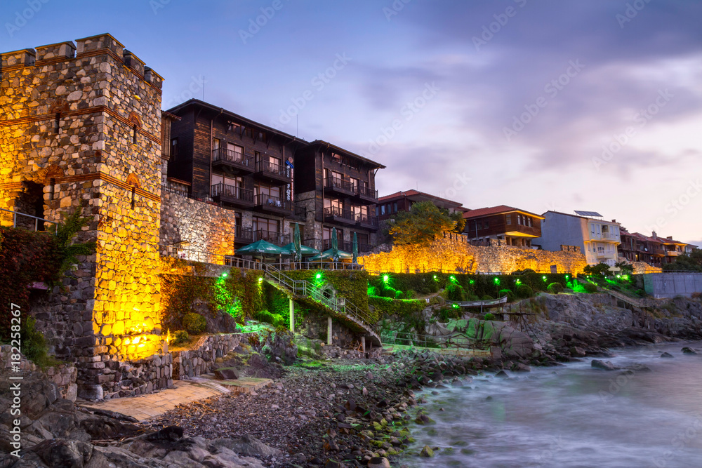 Seaside sunset landscape - fortress wall and tower with illumination in the city of Sozopol on the Black Sea coast in Bulgaria Seaside sunset landscape - fortress wall and tower with illumination in the city of Sozopol on the Black Sea coast in Bulgaria