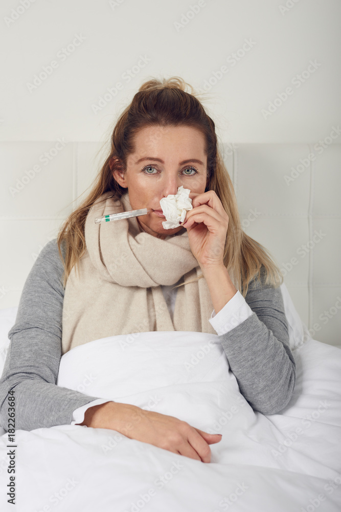 Frau im Bett misst ihre Temperatur Frau im Bett misst ihre Temperatur