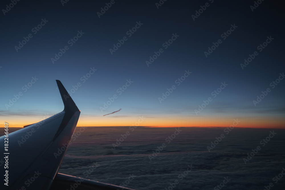 aerial view of plane wing in sunrise during flight aerial view of plane wing in sunrise during flight