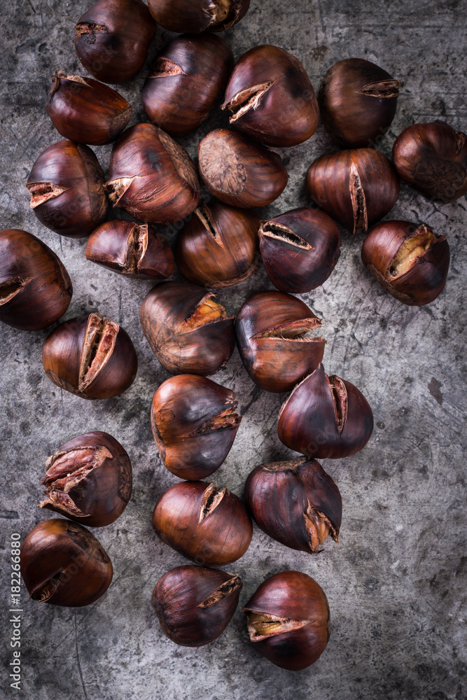 Roasted chestnuts on an old board. healthy food concept Roasted chestnuts on an old board. healthy food concept