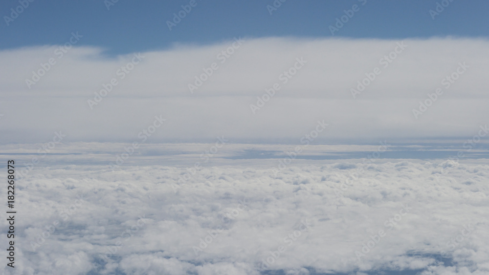 aerial shot from plane flying above the clouds in daytime