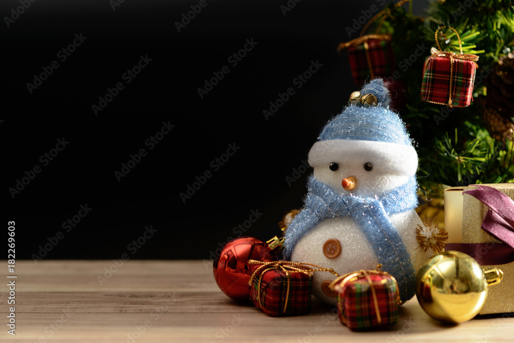 Happy snowman standing in dark winter christmas snow background. Merry christmas and happy new year greeting card with copy-space. Christmas celebration holiday background.