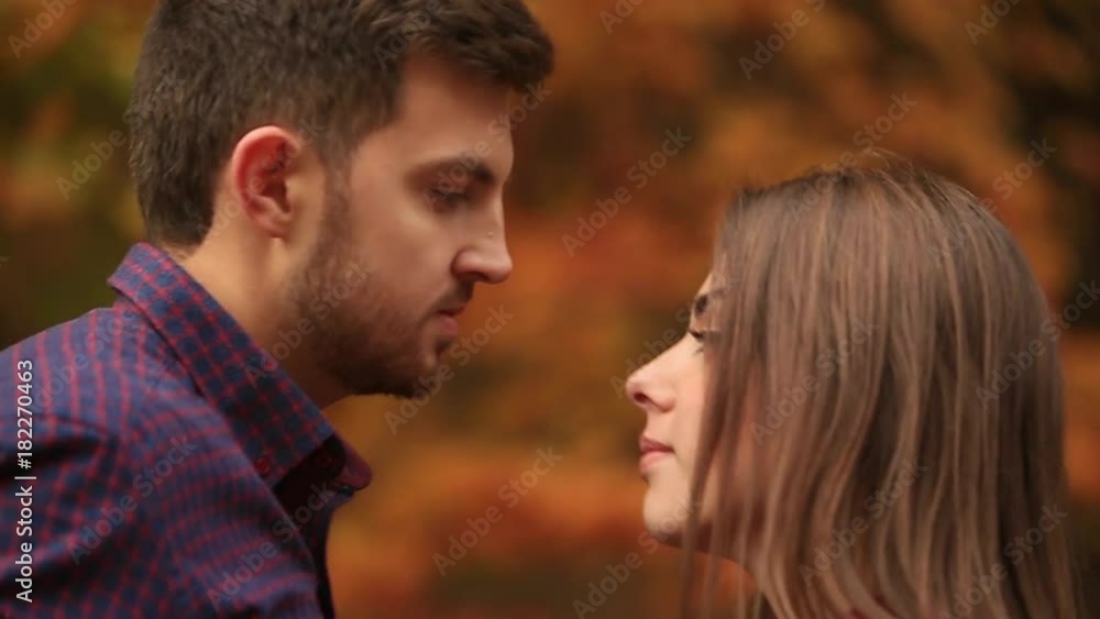 A loving couple walks in the autumn in the park. A love story on a sunny autumn day. lake and bringe . A loving couple walks in the autumn in the park. A love story on a sunny autumn day. lake and bringe .