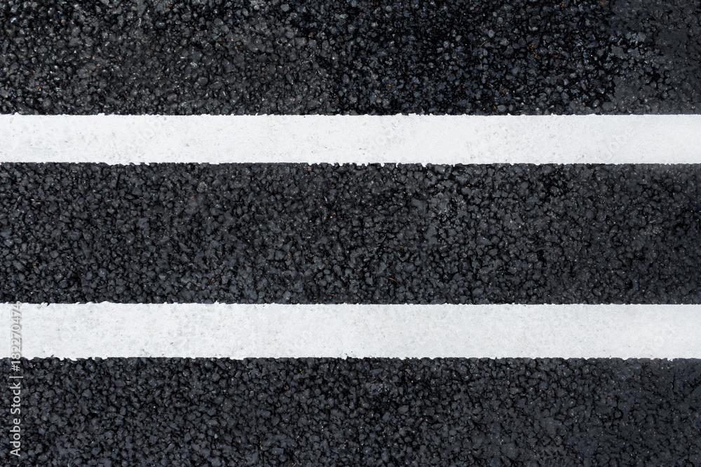 Fototapeta premium Two parallel white marking line on the asphalt road (background, texture, abstract)