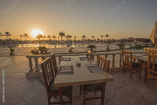 Outdoor dining table  with sunset in tropical hotel resort