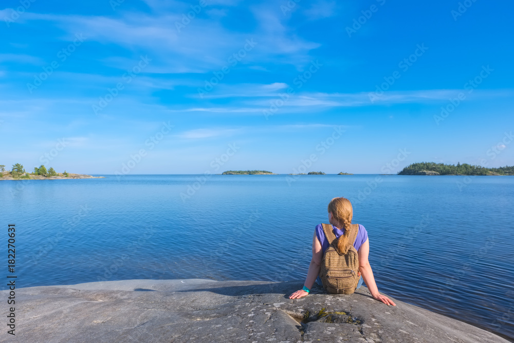Landscape on a big lake and a girl sitting on a stone shore Stock Photo ...