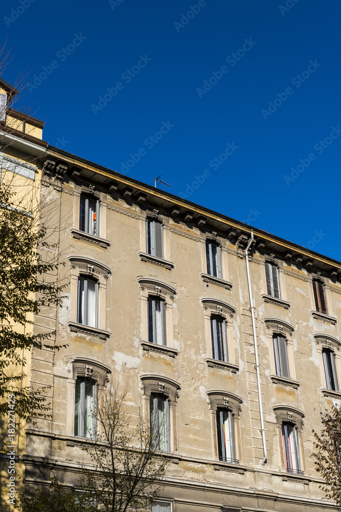 Worn out traditional architecture in Milan, Lombardy, Italy with blue sky