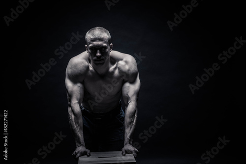 Portrait of a handsome male bodybuilder, on a black background isolated. monochrome. The concept of a photo of competing sports, health, fitness