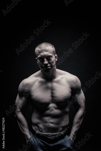 Portrait of a handsome male bodybuilder, on a black background isolated. monochrome. The concept of a photo of competing sports, health, fitness