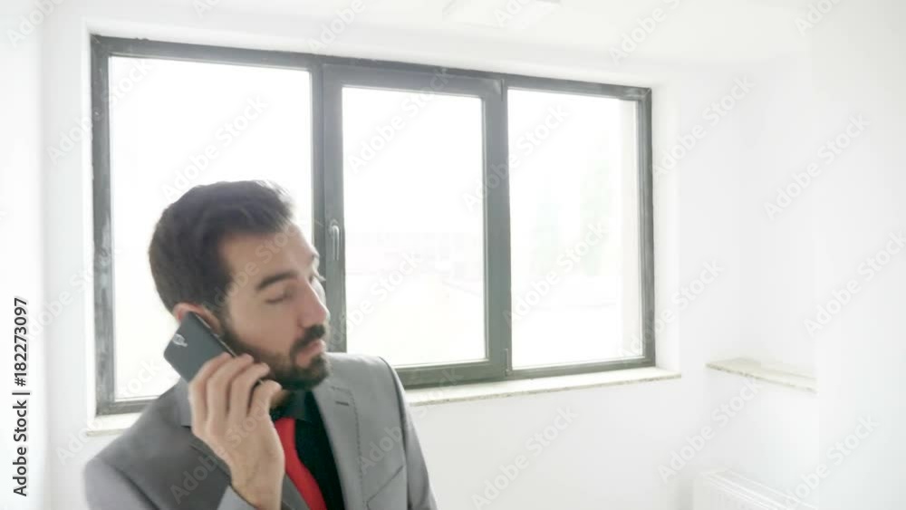 Businessman in formal suit talking on the phone while climbing stairs in an office building. Communication and finance Businessman in formal suit talking on the phone while climbing stairs in an office building. Communication and finance