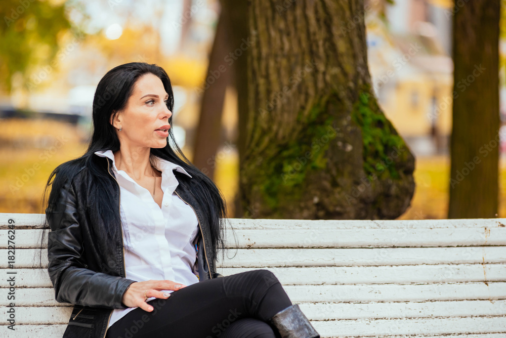 portrait of a beautiful young girl sitting on a bench in an autumn park portrait of a beautiful young girl sitting on a bench in an autumn park