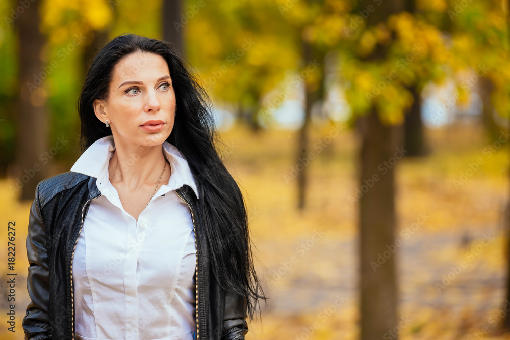 portrait of a beautiful young girl walking along an autumn park in fashionable clothes portrait of a beautiful young girl walking along an autumn park in fashionable clothes