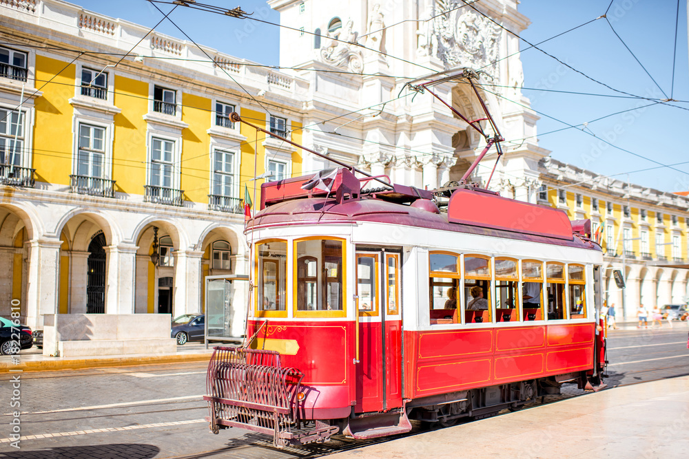 Old tourist tram on the central square with Augusta arch on the background in Lisbon, Portugal