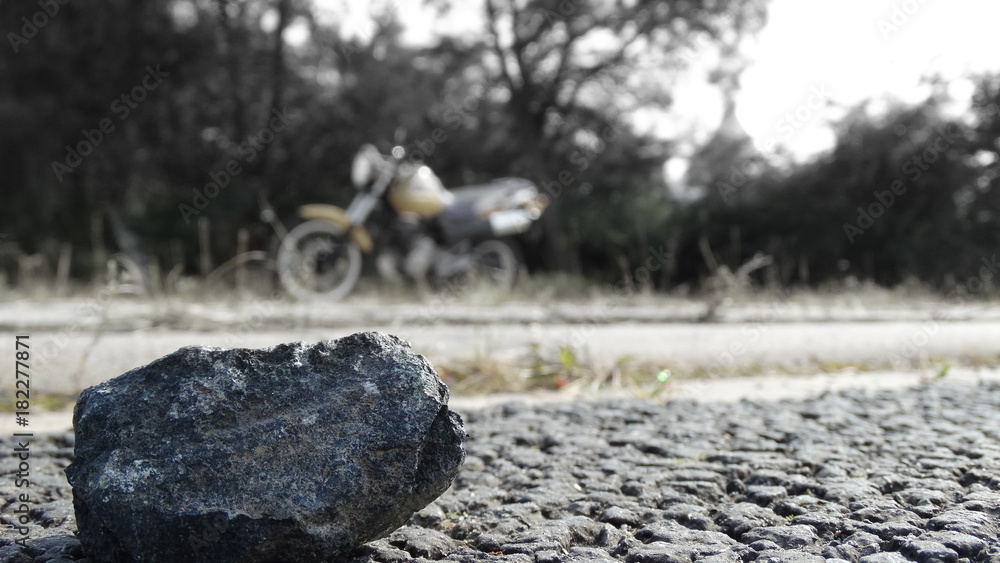 Naklejka premium Stein Stone Macro mit Motorrad im Hintergrund (Honda SLR650)