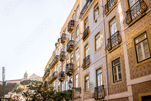 Fototapeta Naklejka Na Ścianę i Meble -  Beautiful street view with beautiful residential buildings in Mouraria district during the morning light in Lisbon city, Portugal