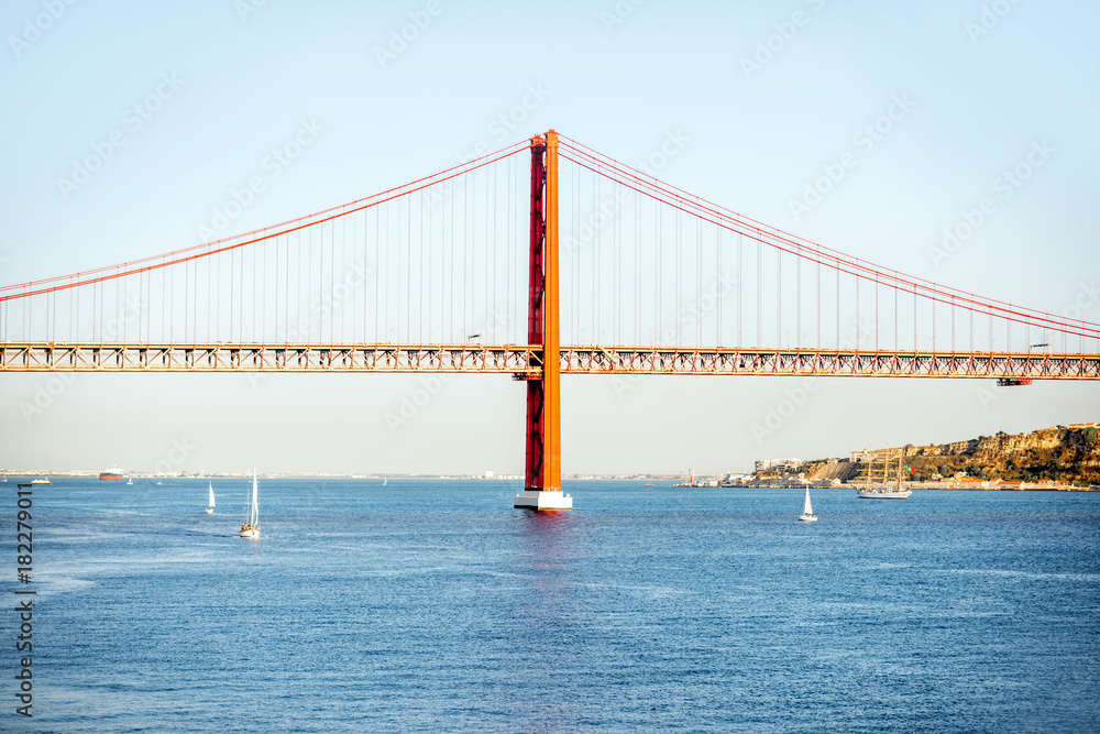 Landscape view on the 25th of April Bridge during the sunset in Lisbon city, Portugal Landscape view on the 25th of April Bridge during the sunset in Lisbon city, Portugal