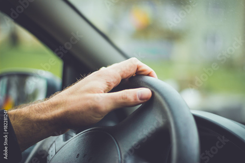Hand on steering wheel. Man driving