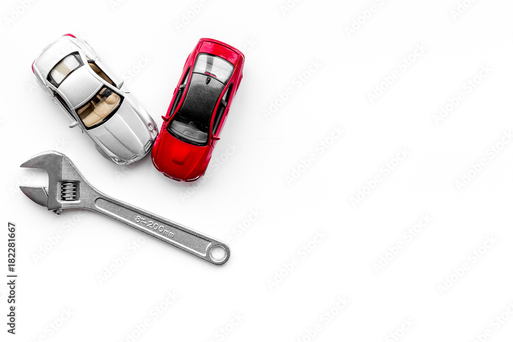 Car repair concept. Wrench near car toys on white background top view copyspace Car repair concept. Wrench near car toys on white background top view copyspace